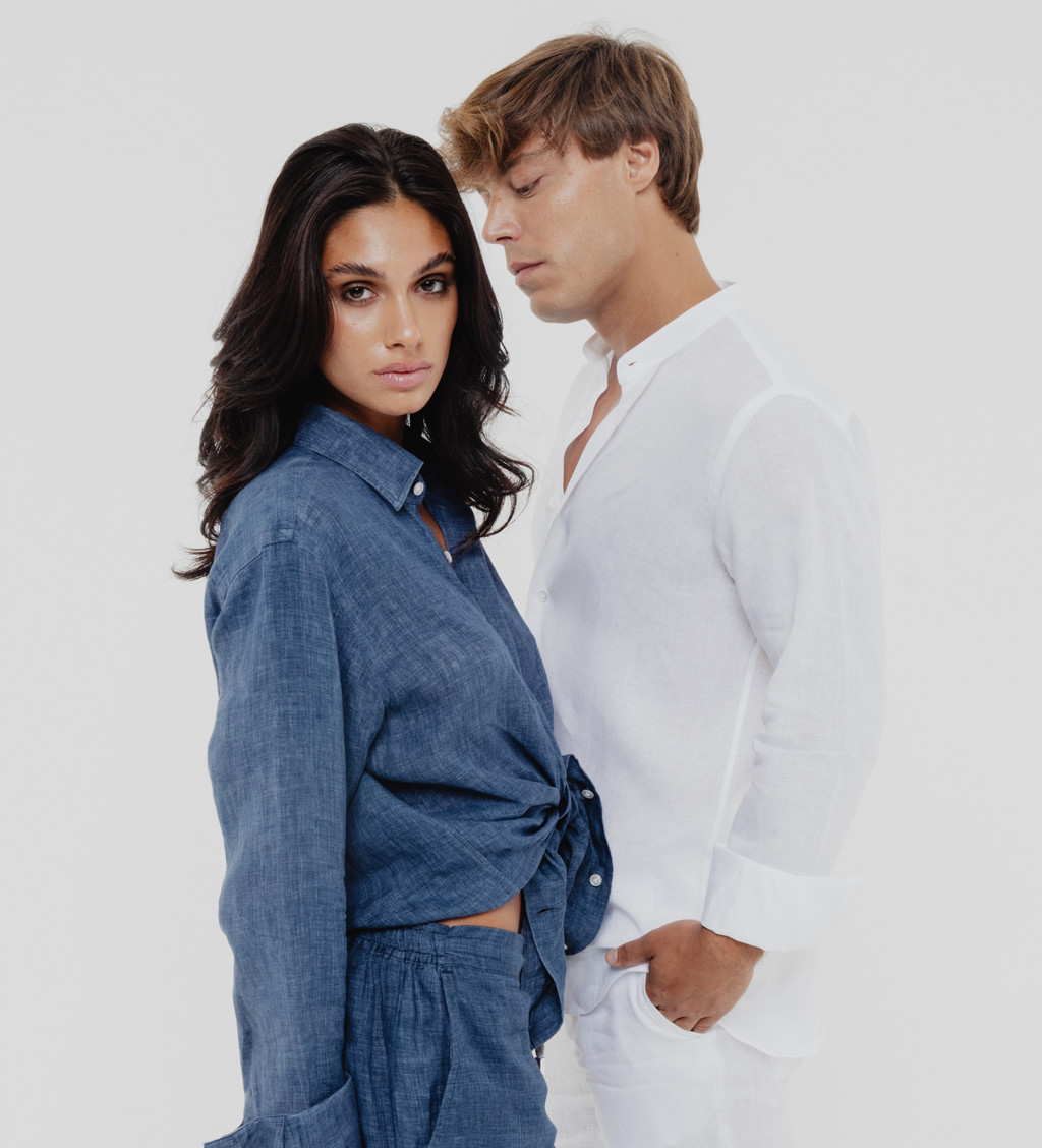 Two people standing close together against a plain background